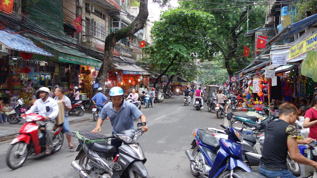 Motorbikes travelling through a Vietnamese city street, illustrating commuter travel options in Hanoi