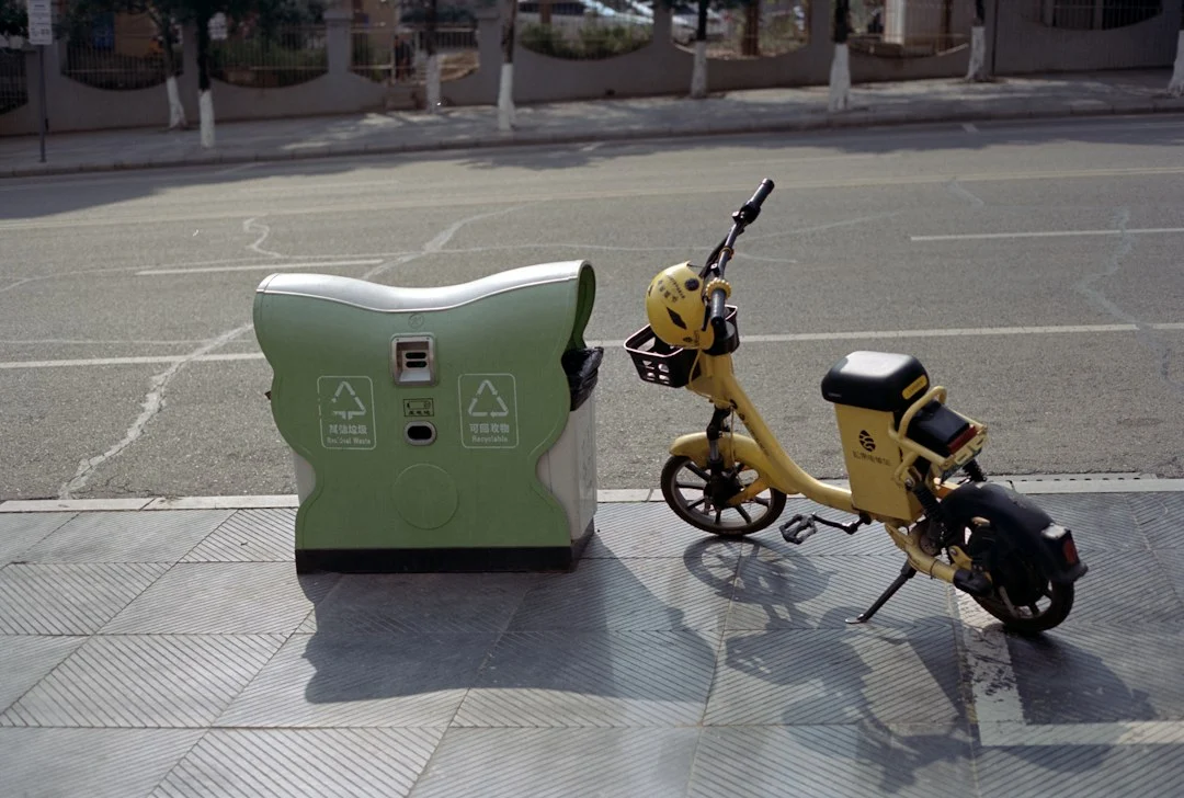 Scooter amarillo junto a un equipo verde en un entorno urbano, imagen ilustrativa de movilidad eléctrica
