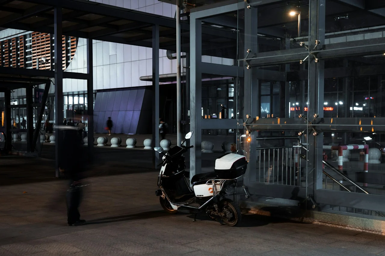 Deux-roues stationné devant un immeuble moderne, illustration du stationnement pour la location électrique à Hanoï
