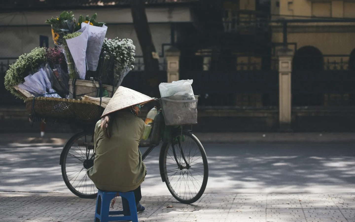 Vendeuse de fleurs dans une rue vietnamienne, image illustrative de moyens de transport possibles à Hanoï