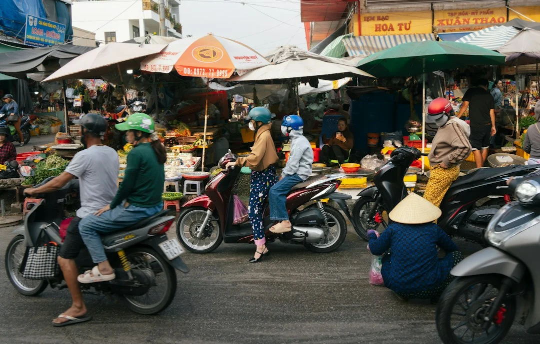 Marché animé avec des motos dans une rue du Viêt Nam, photo illustrative des déplacements à Hanoï