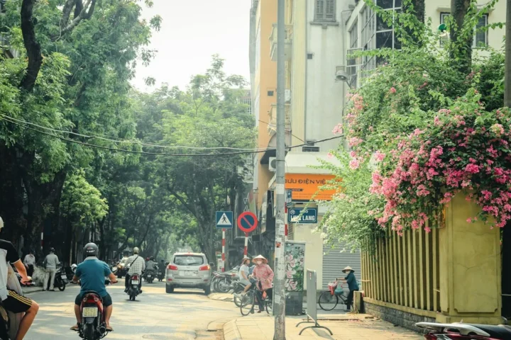 Rue vietnamienne avec motos et fleurs, photo illustrant les déplacements des étudiants à Hanoï