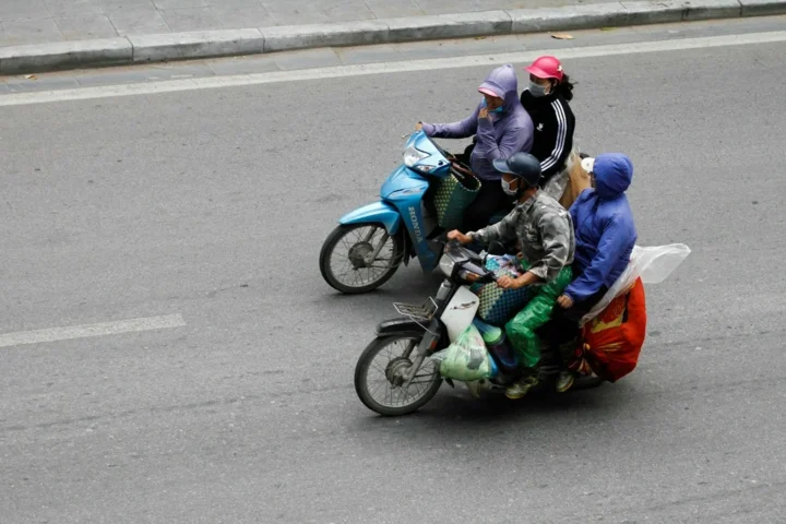 Người tham gia giao thông bằng xe máy trên đường phố, minh họa việc sinh viên so sánh các phương tiện đi lại tại Hà Nội