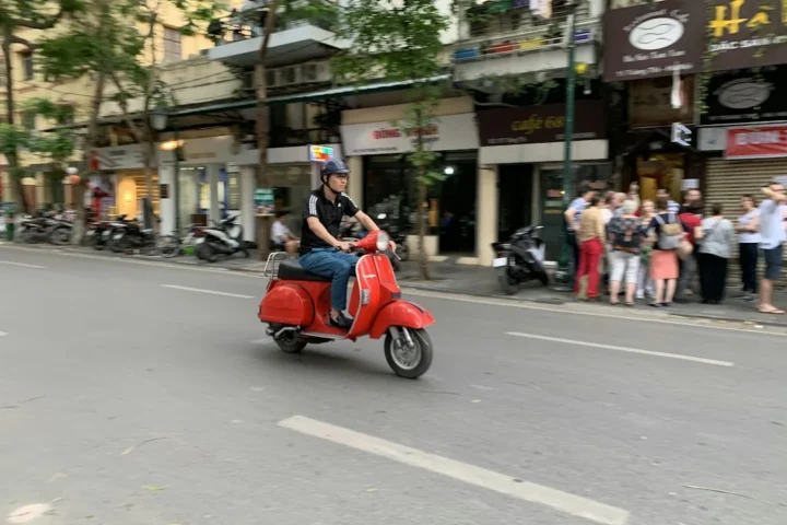 Motorbike riders on an urban road in daylight, illustrating student commuting and rental safety in Hanoi