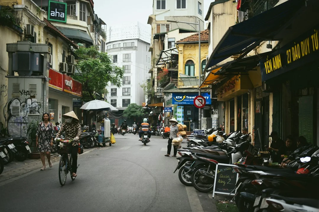 Phố Hà Nội với xe máy đỗ bên đường và người đi xe đạp, minh họa nhu cầu đi học và thuê xe máy của sinh viên