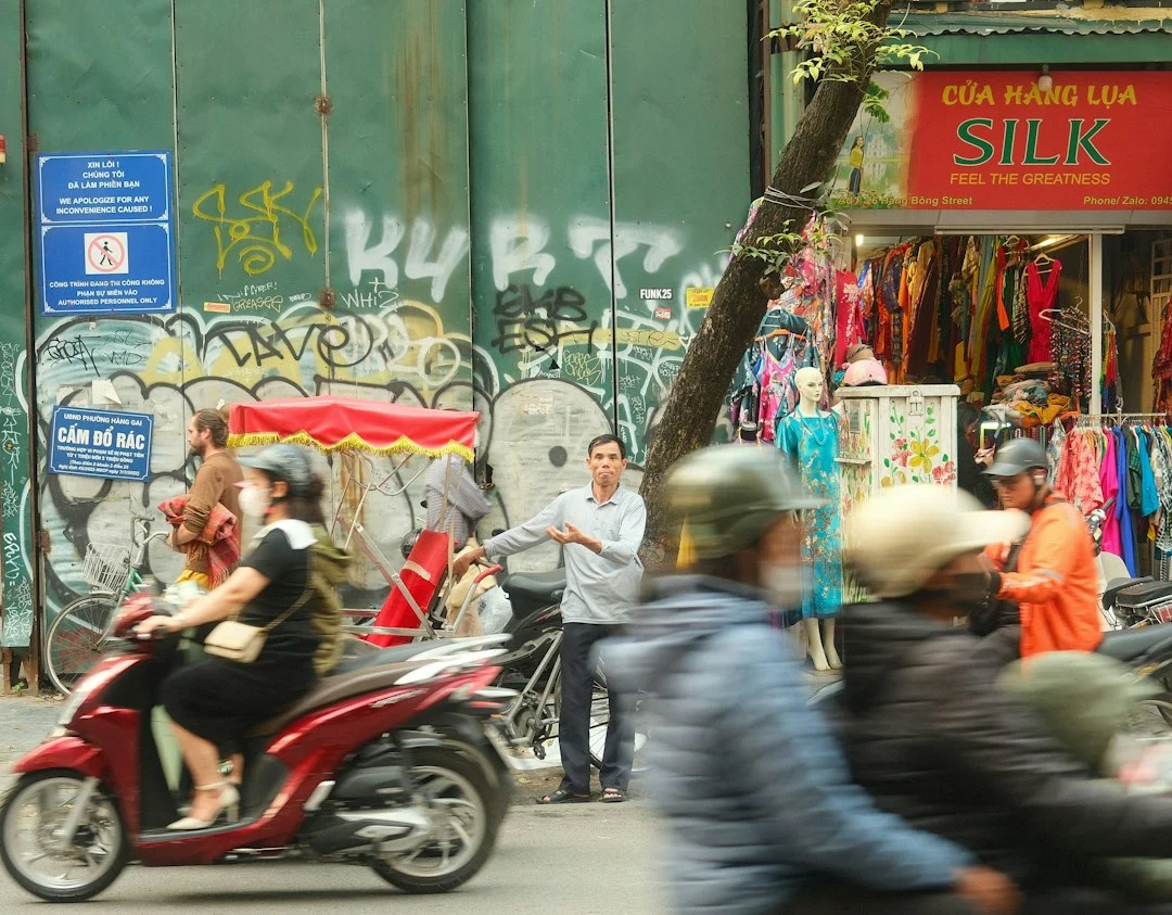 Dòng xe tay ga và giao thông trước cửa hàng trên phố, minh họa tìm hiểu thuê xe ga 50cc Hà Nội