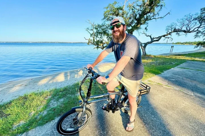 Personne faisant du vélo électrique au bord d'un lac, illustration du pédalage assisté
