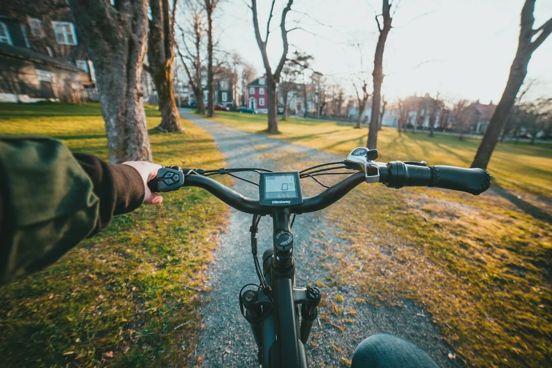 Vue depuis un vélo électrique sur un chemin ensoleillé, illustration du pédalage assisté et de son autonomie